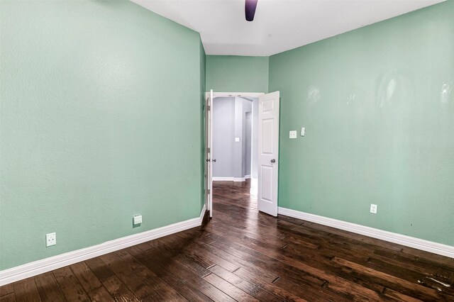 empty room featuring ceiling fan and dark hardwood / wood-style flooring