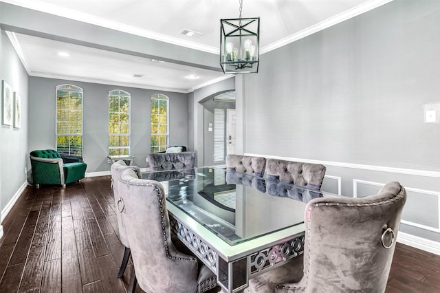 dining area with dark hardwood / wood-style floors, an inviting chandelier, and crown molding