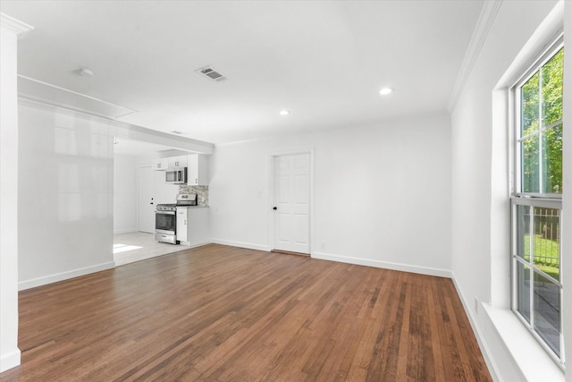 unfurnished living room with crown molding and wood-type flooring