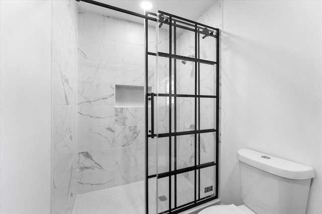 bathroom featuring a tile shower and toilet