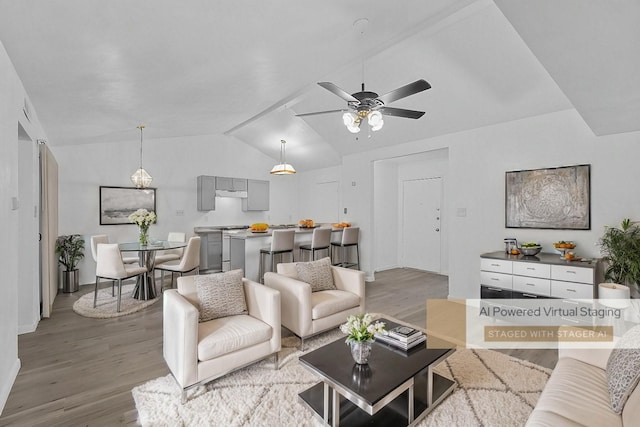 living room with ceiling fan, light hardwood / wood-style flooring, and vaulted ceiling