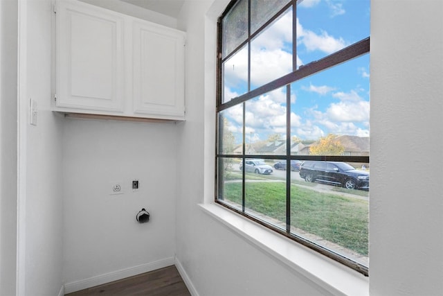 laundry room with hookup for an electric dryer, dark hardwood / wood-style floors, and cabinets