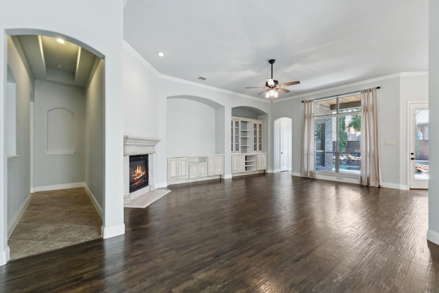 unfurnished living room featuring ceiling fan, dark hardwood / wood-style floors, and ornamental molding