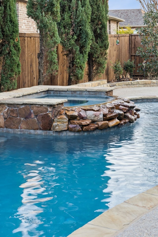 view of pool with an in ground hot tub