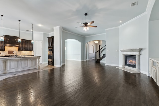 living room featuring dark hardwood / wood-style flooring, ceiling fan, sink, and ornamental molding