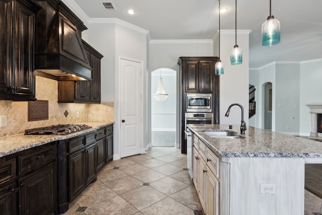 kitchen featuring appliances with stainless steel finishes, ornamental molding, sink, and premium range hood