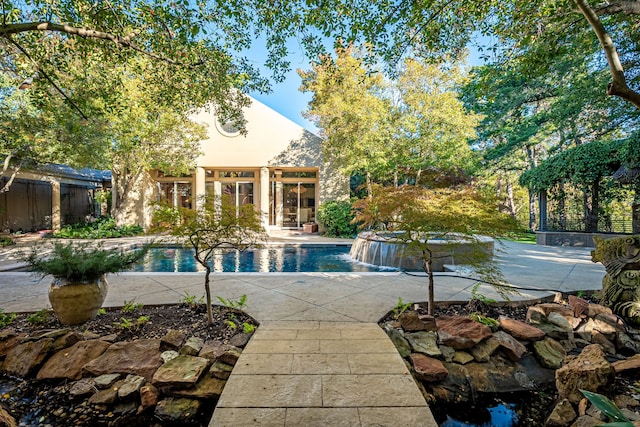 view of swimming pool with pool water feature and a patio area