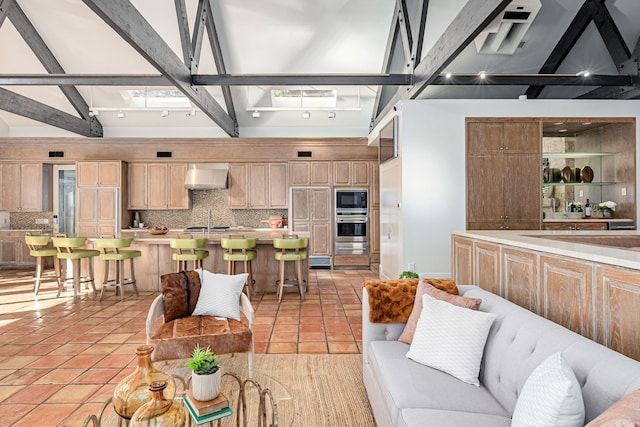 tiled living room featuring beam ceiling and sink