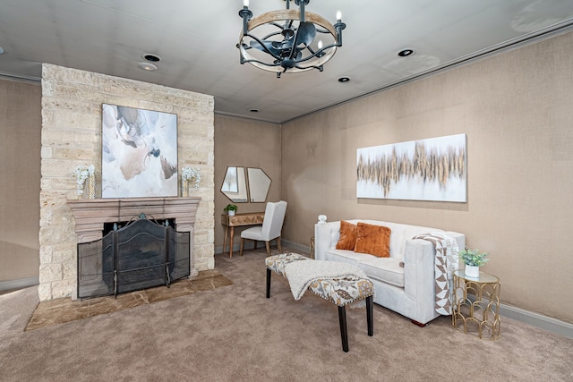 carpeted living room with a stone fireplace and a chandelier