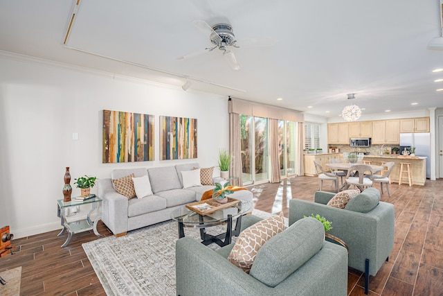 living room featuring ceiling fan, ornamental molding, and dark wood-type flooring