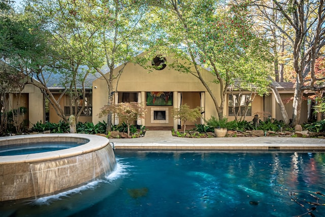 view of swimming pool featuring an in ground hot tub, a fireplace, and pool water feature