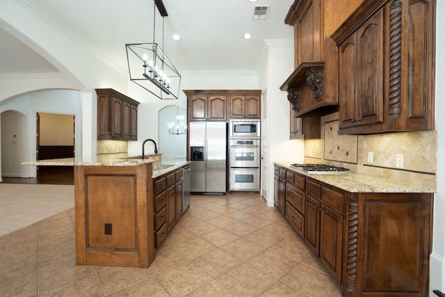 kitchen featuring decorative light fixtures, stainless steel appliances, ornamental molding, and sink