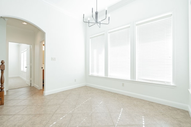 unfurnished room with light tile patterned floors, crown molding, and an inviting chandelier