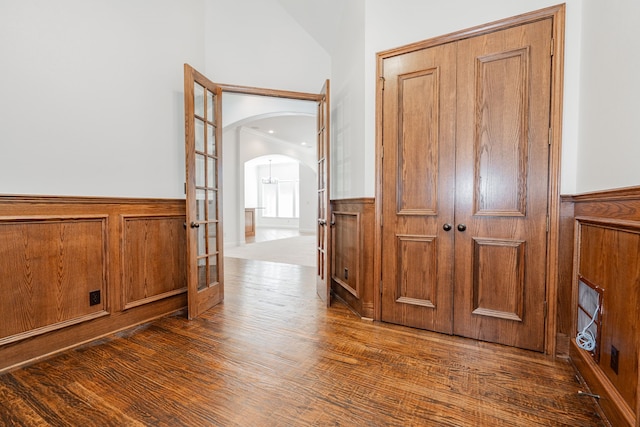 corridor featuring french doors, dark hardwood / wood-style flooring, and lofted ceiling