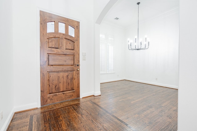 entryway featuring a notable chandelier, dark hardwood / wood-style floors, and ornamental molding