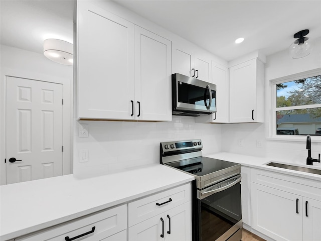 1008 Calcutta St, Hurst, TX 76053 - kitchen featuring stainless steel appliances, a sink, backsplash, white cabinets, and light countertops