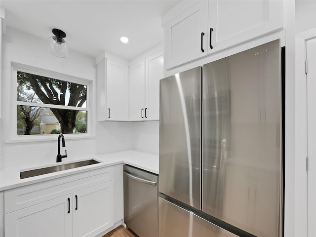 kitchen featuring tasteful backsplash, appliances with stainless steel finishes, sink, and white cabinets