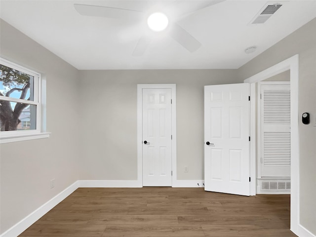 unfurnished bedroom with dark hardwood / wood-style floors and ceiling fan