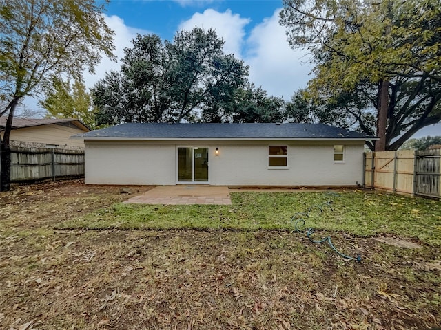 back of property with a patio area and a lawn