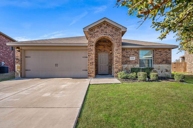 ranch-style home featuring a garage, a front yard, and central air condition unit