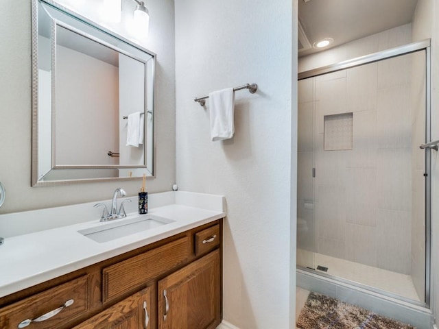 bathroom with vanity and a shower with door