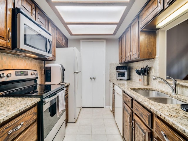 kitchen featuring sink, light tile patterned floors, stainless steel appliances, and tasteful backsplash