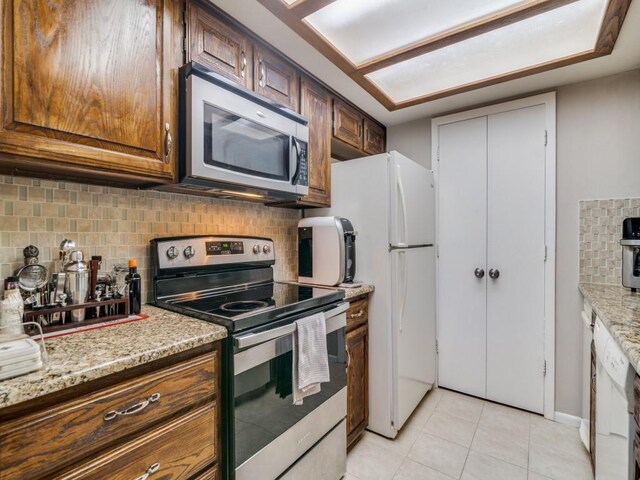 kitchen featuring light stone counters, backsplash, and appliances with stainless steel finishes