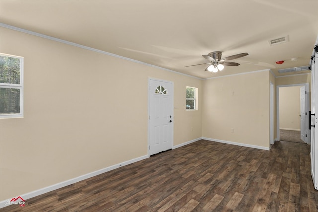 empty room featuring ornamental molding, plenty of natural light, and dark wood-type flooring