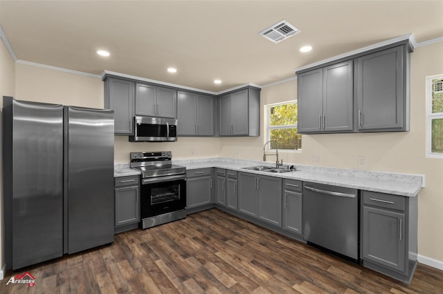 kitchen featuring dark hardwood / wood-style flooring, ornamental molding, gray cabinetry, stainless steel appliances, and sink