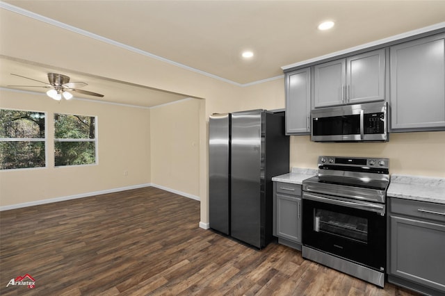 kitchen with gray cabinetry, ceiling fan, ornamental molding, appliances with stainless steel finishes, and dark hardwood / wood-style flooring