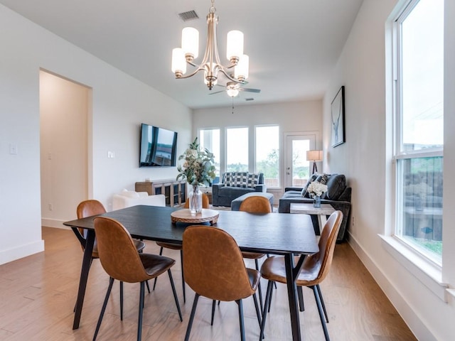 dining area featuring ceiling fan with notable chandelier and light hardwood / wood-style flooring