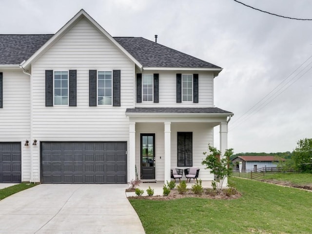 view of front of property featuring covered porch, a front yard, and a garage