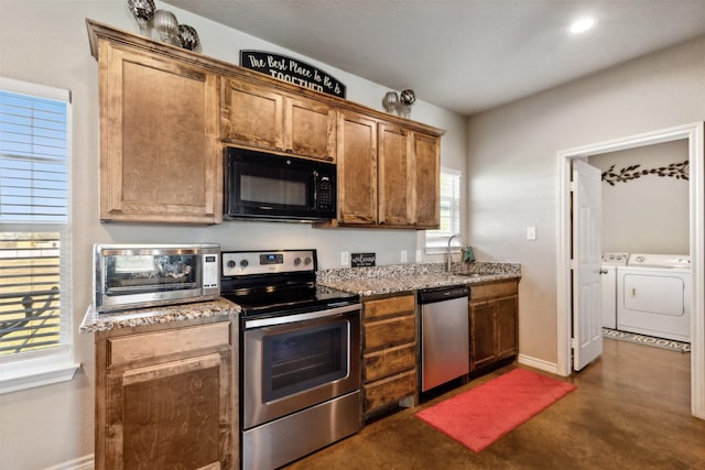 kitchen with washing machine and dryer, sink, and appliances with stainless steel finishes