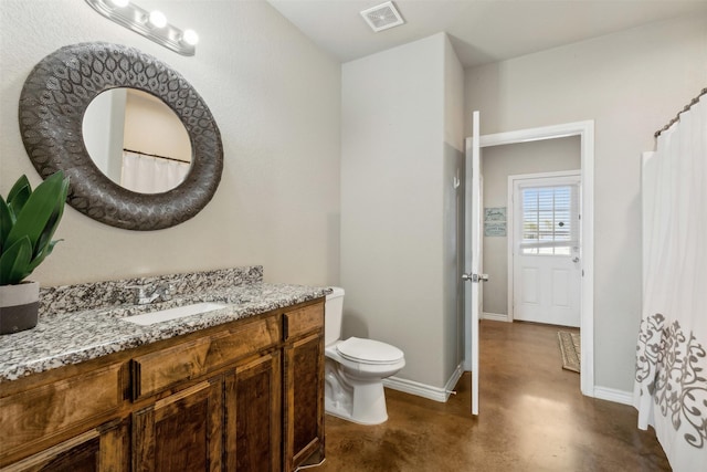 bathroom with vanity, concrete floors, and toilet