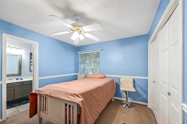 carpeted bedroom featuring ceiling fan, a closet, and a textured ceiling