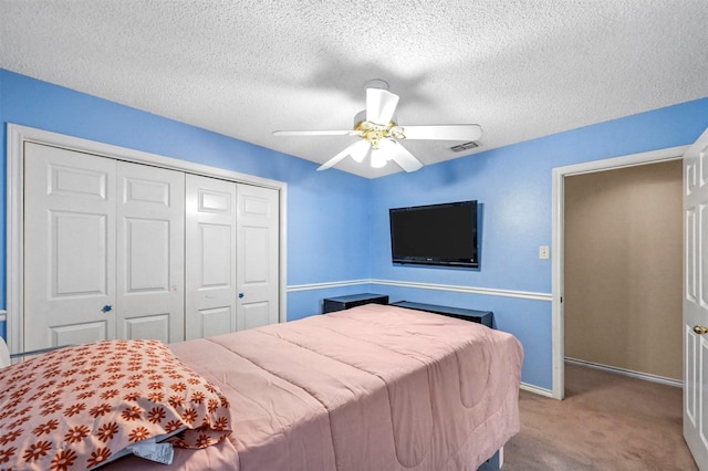 bedroom with light carpet, a textured ceiling, a closet, and ceiling fan