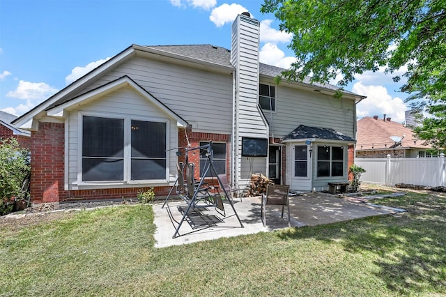 back of house with a yard and a patio