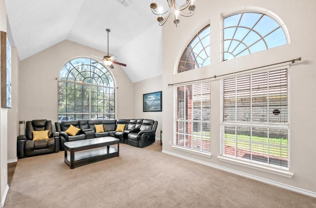 carpeted living room with ceiling fan with notable chandelier and lofted ceiling