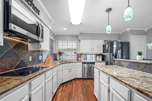 kitchen with sink, decorative light fixtures, white cabinetry, and black appliances