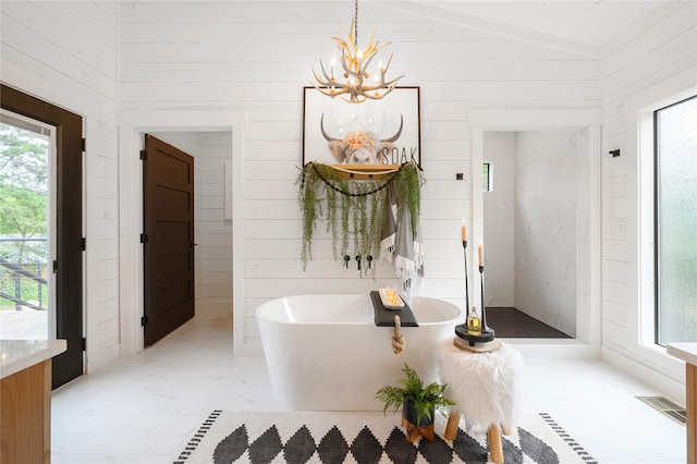 bathroom featuring a chandelier, a bath, lofted ceiling, and wood walls