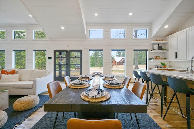 dining area with wooden ceiling, french doors, sink, vaulted ceiling with beams, and light hardwood / wood-style floors