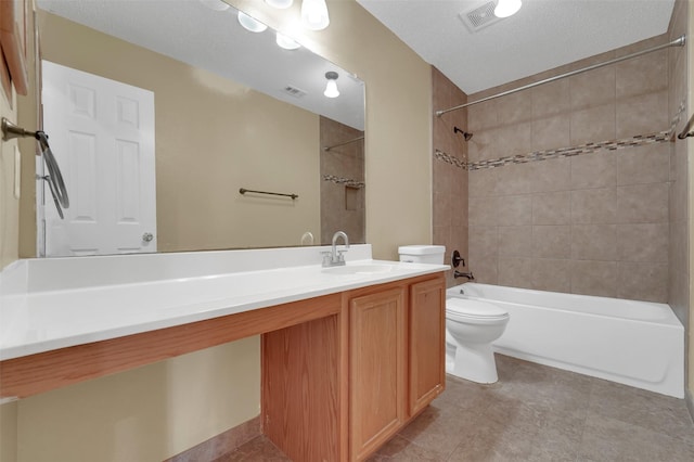 full bathroom featuring vanity, tile patterned flooring, tiled shower / bath combo, toilet, and a textured ceiling