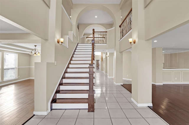 stairs with a chandelier, hardwood / wood-style flooring, and ornamental molding