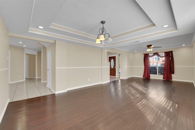 unfurnished living room featuring hardwood / wood-style flooring and a raised ceiling