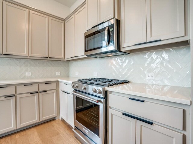 kitchen featuring tasteful backsplash, light hardwood / wood-style flooring, and stainless steel appliances