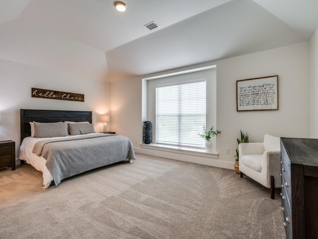 bedroom featuring lofted ceiling and light carpet