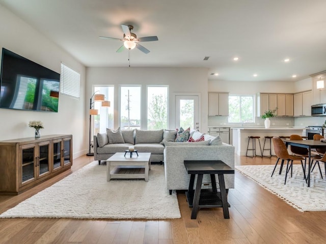 living room featuring light hardwood / wood-style flooring and ceiling fan