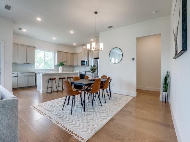 dining space featuring a chandelier and light wood-type flooring