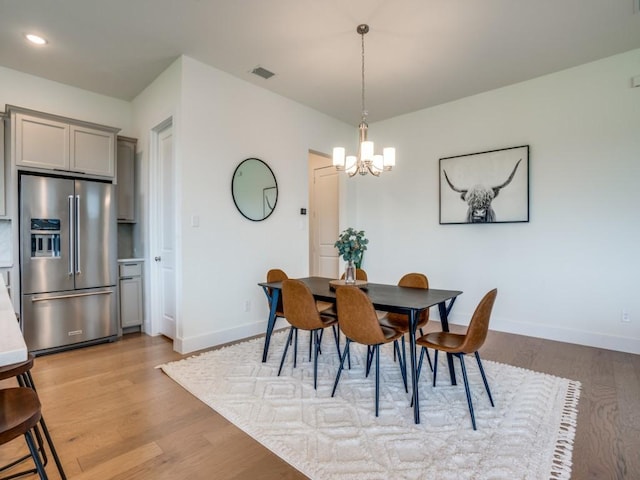 dining area featuring a notable chandelier and light hardwood / wood-style floors