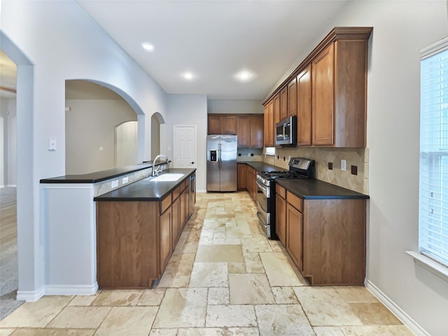 kitchen featuring decorative backsplash, sink, and stainless steel appliances